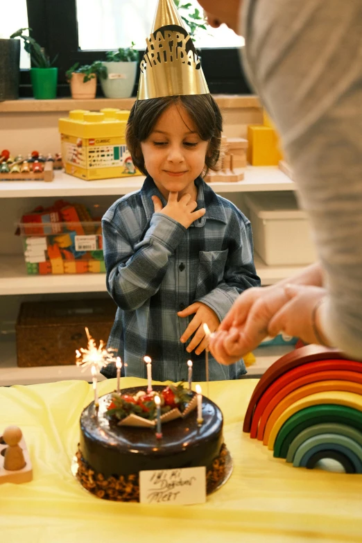 a  standing next to a birthday cake on top of a table