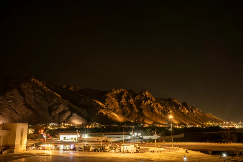 night scene of mountains with a parking lot on the ground