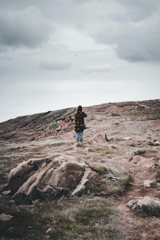 a man standing on top of a rocky hill