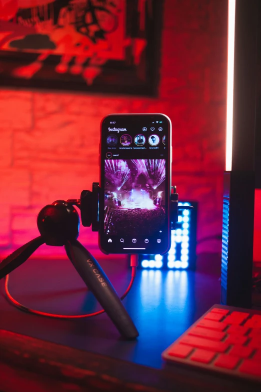 a phone in the front of a tripod next to a keyboard