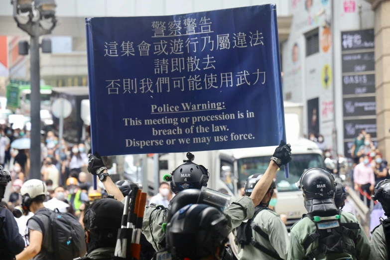 a group of police officers and a man holding a protest sign