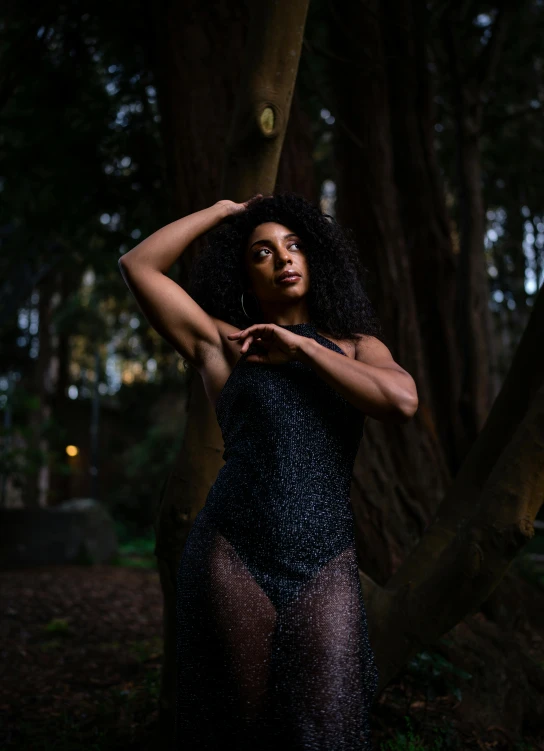 a young lady poses for a po in front of the tree