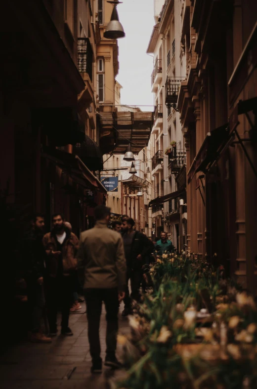 a crowded city street filled with people and flowers