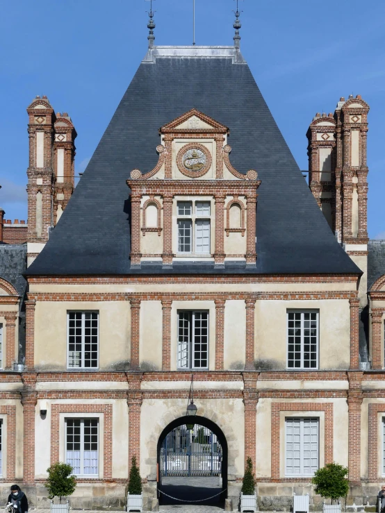 an old style house with a clock on the front