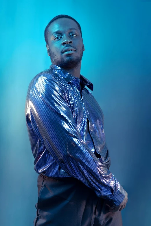 a person in a shiny silver shirt is posing