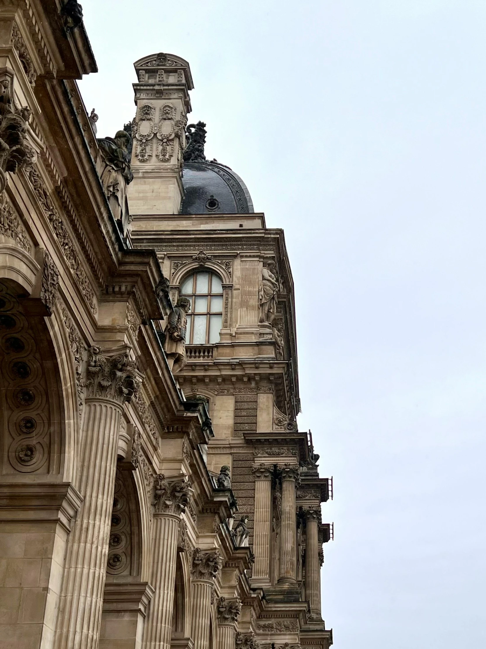 a tall building with columns and an ornate dome