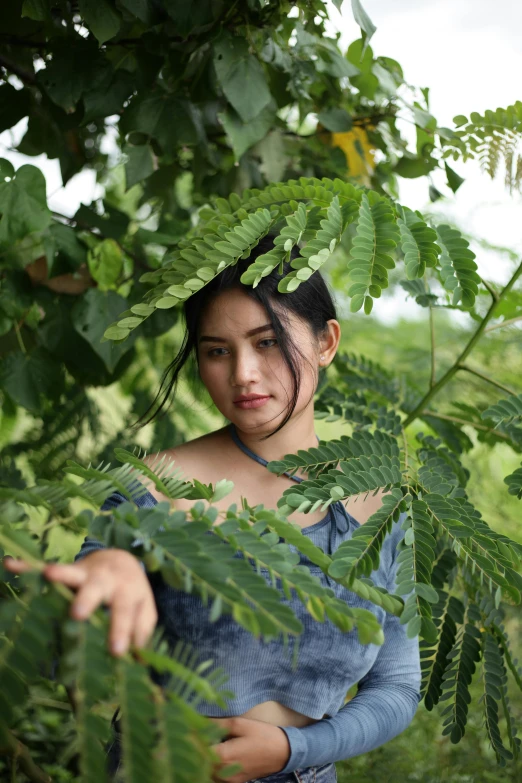 a girl poses for a portrait among leaves