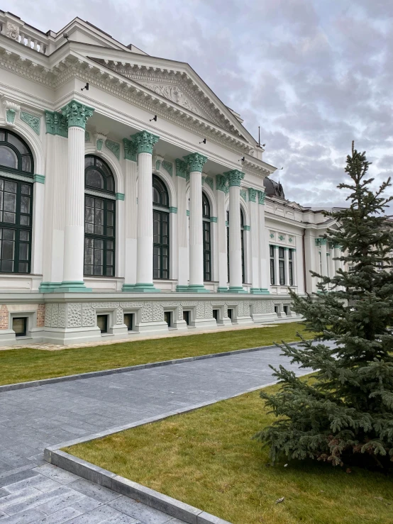 a large white building sitting on the corner of a green lawn