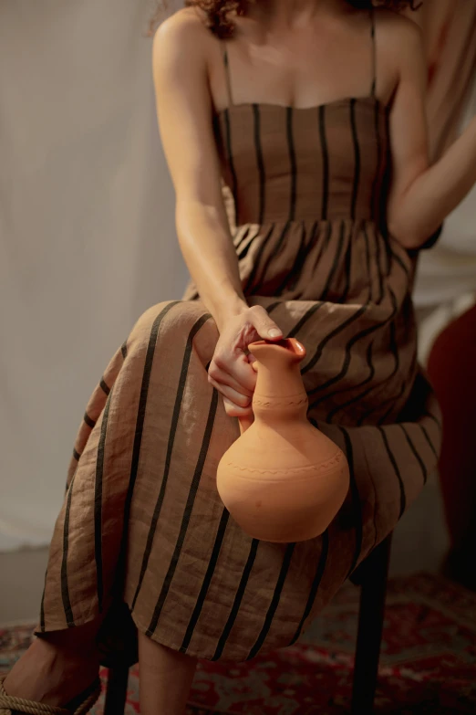 woman sitting with a vase on her lap