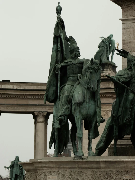 a statue of two men and horses in a city