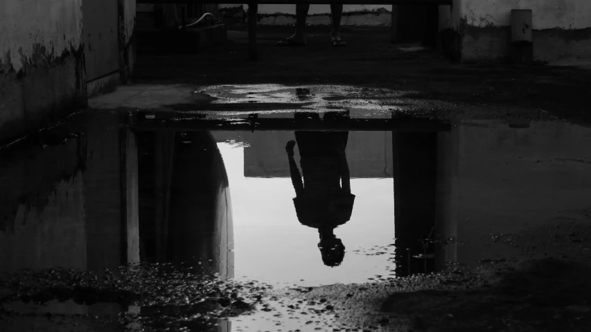 a black and white po of the reflection of a car on the water