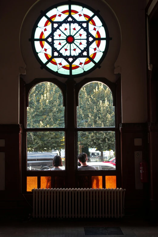 a view through stained glass windows into an empty courtyard