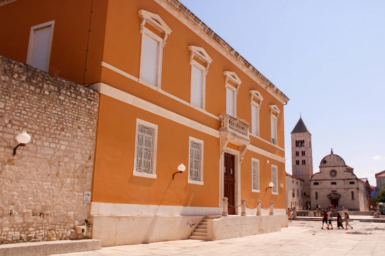 a man riding a horse past an orange building