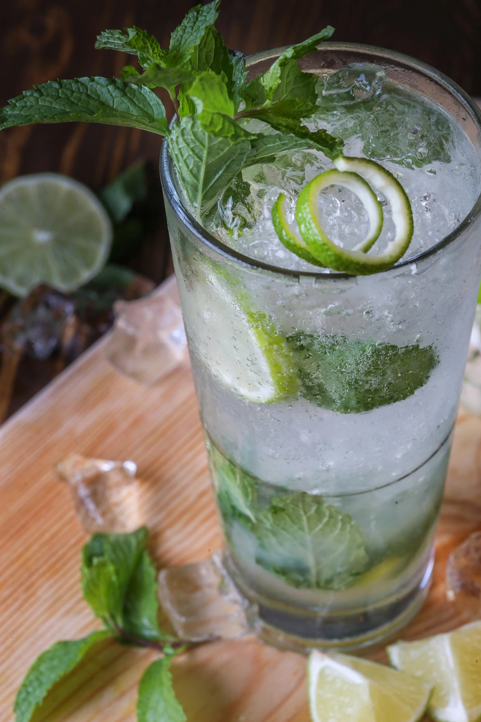 a glass filled with ice, lime and sliced bananas