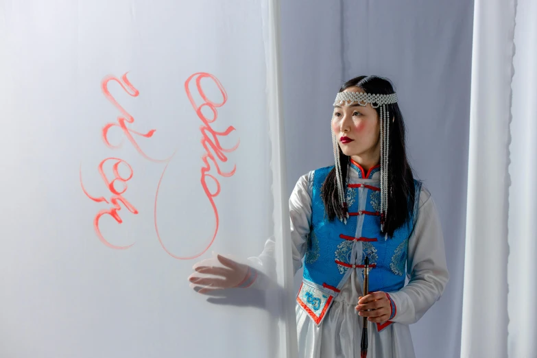 a woman standing in front of a board and a pen