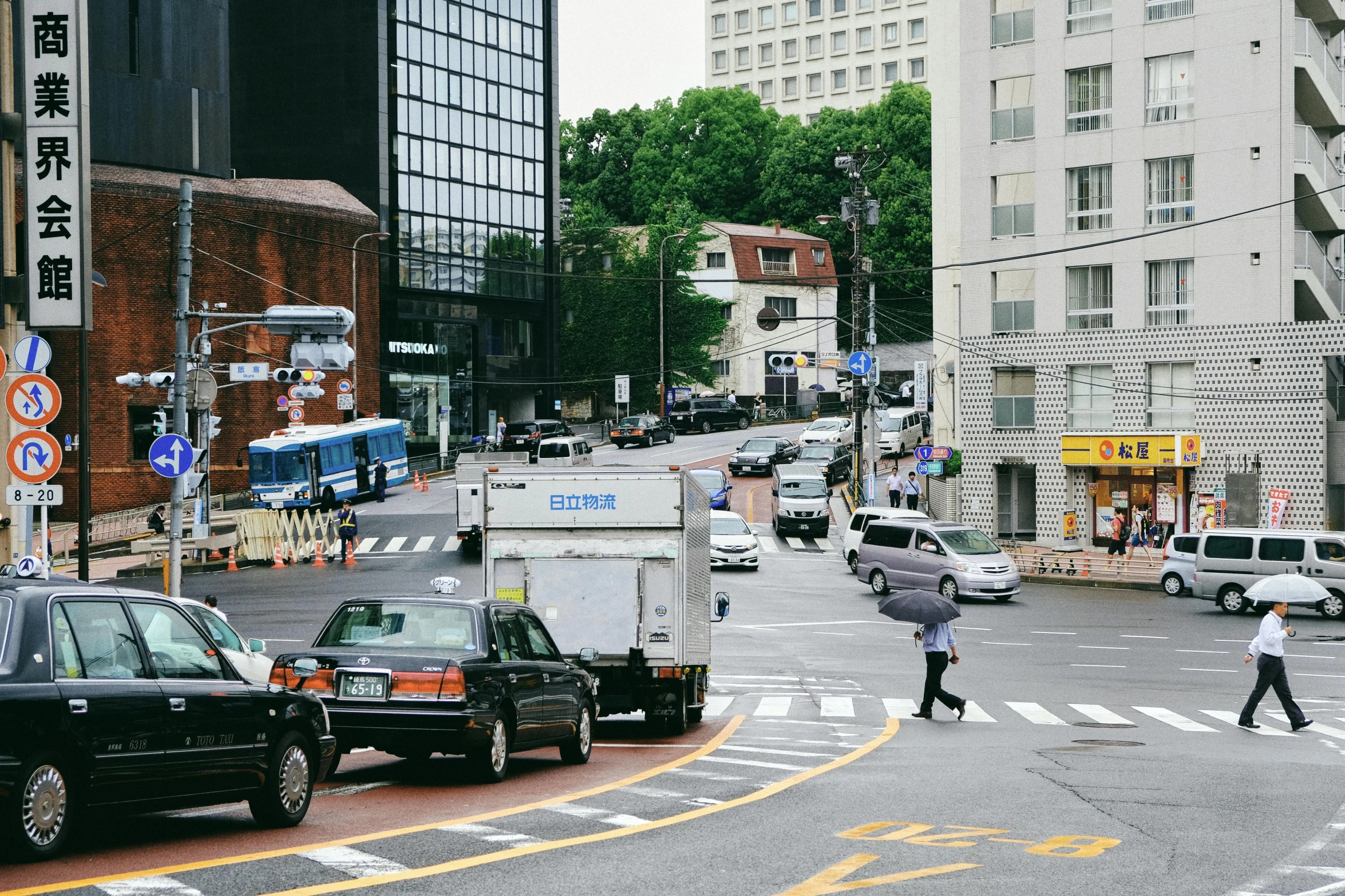 a man walks across the street in front of a group of cars