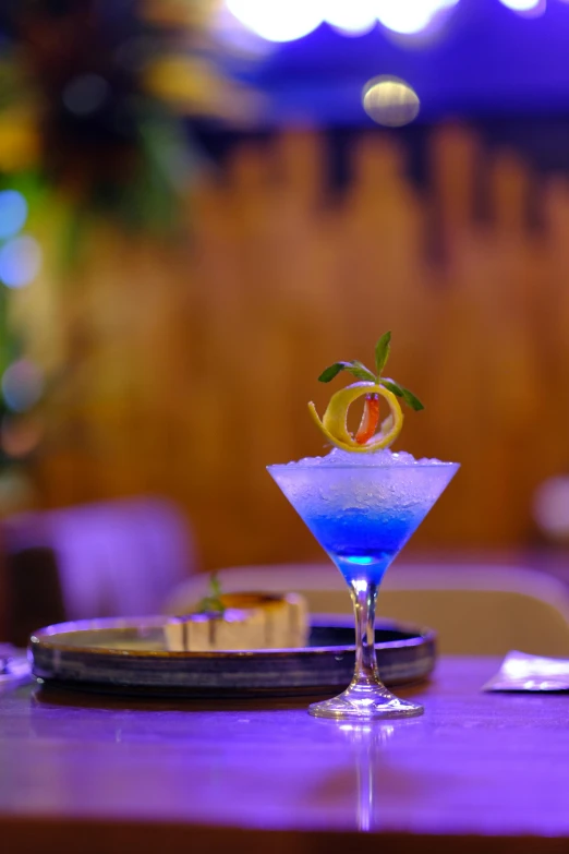 a fancy blue dessert garnished with an orange slice