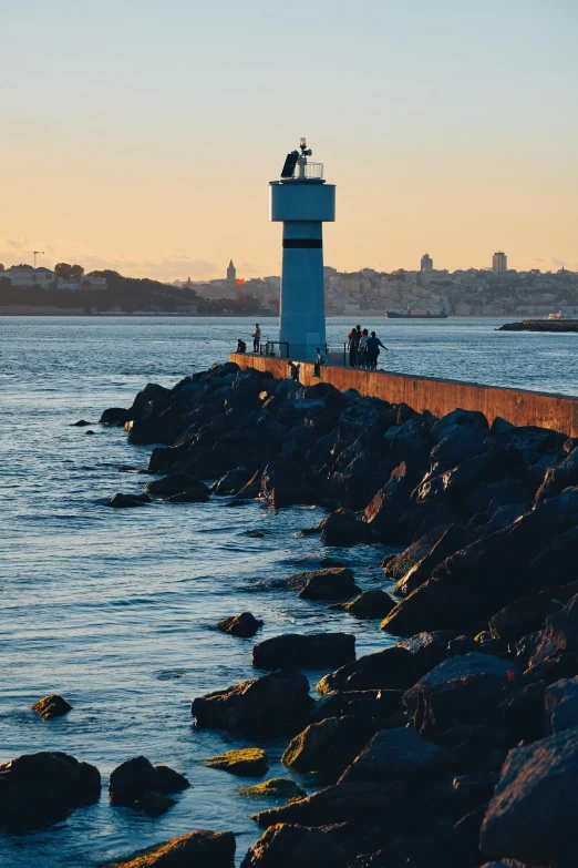 a light house near the water with people on it