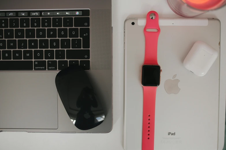 a close up of an apple watch with a computer keyboard and mouse