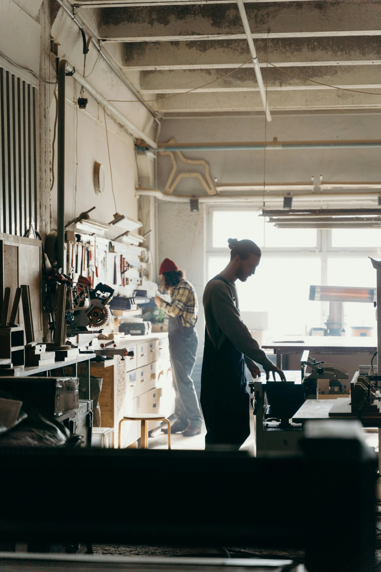 a man and woman in an old building making furniture