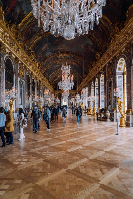 a very large and ornate hall with a chandelier hanging from it's ceiling