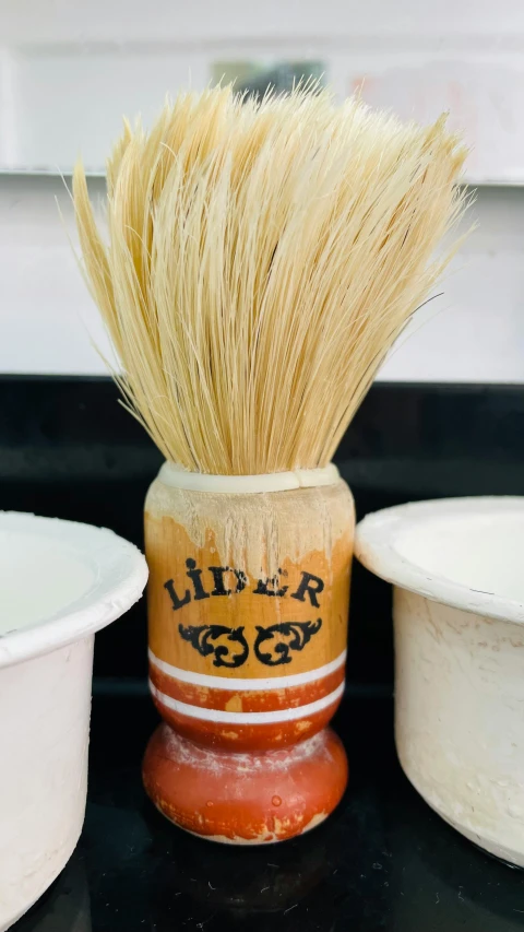 a close up of a shave brush and bowls