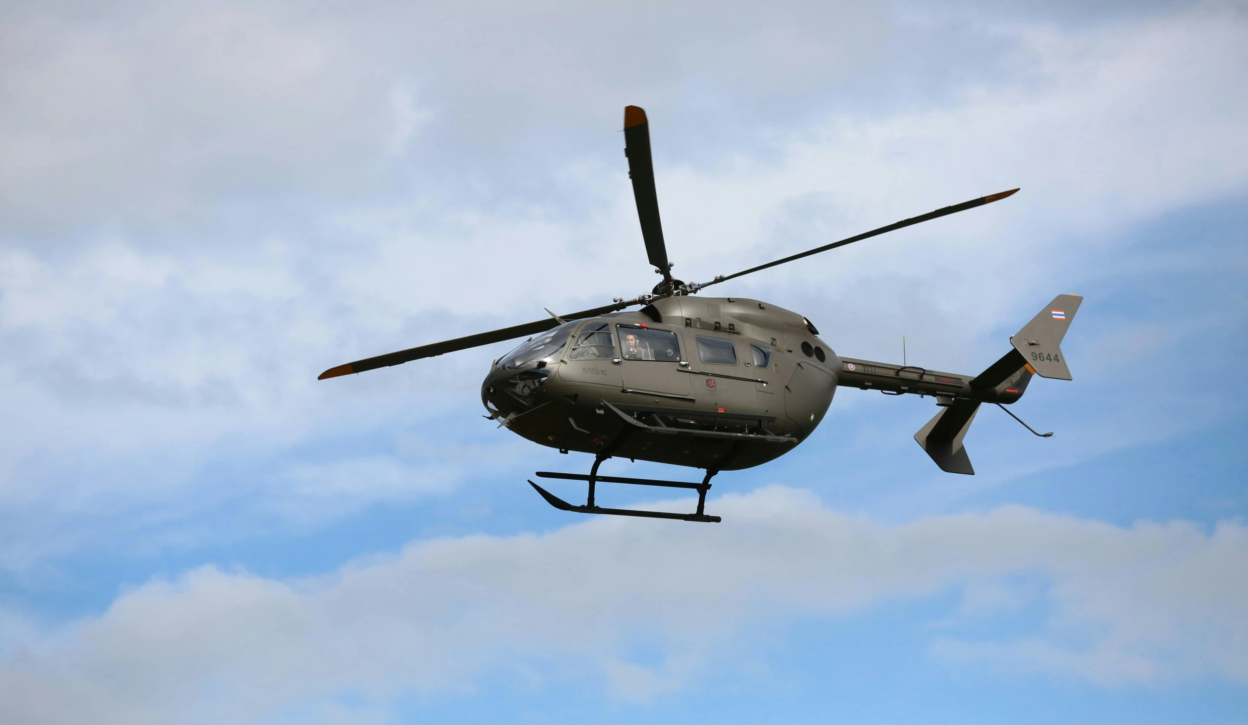 a large silver helicopter flying in the air