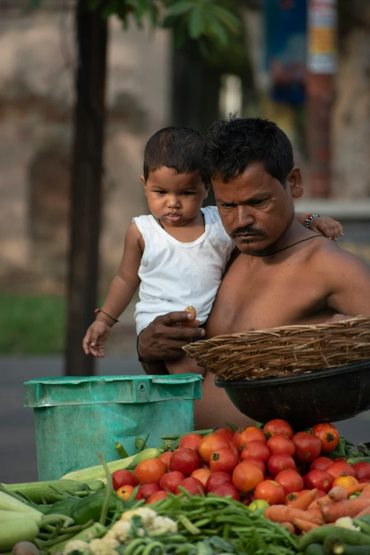 a man sitting on top of a bed of vegetables