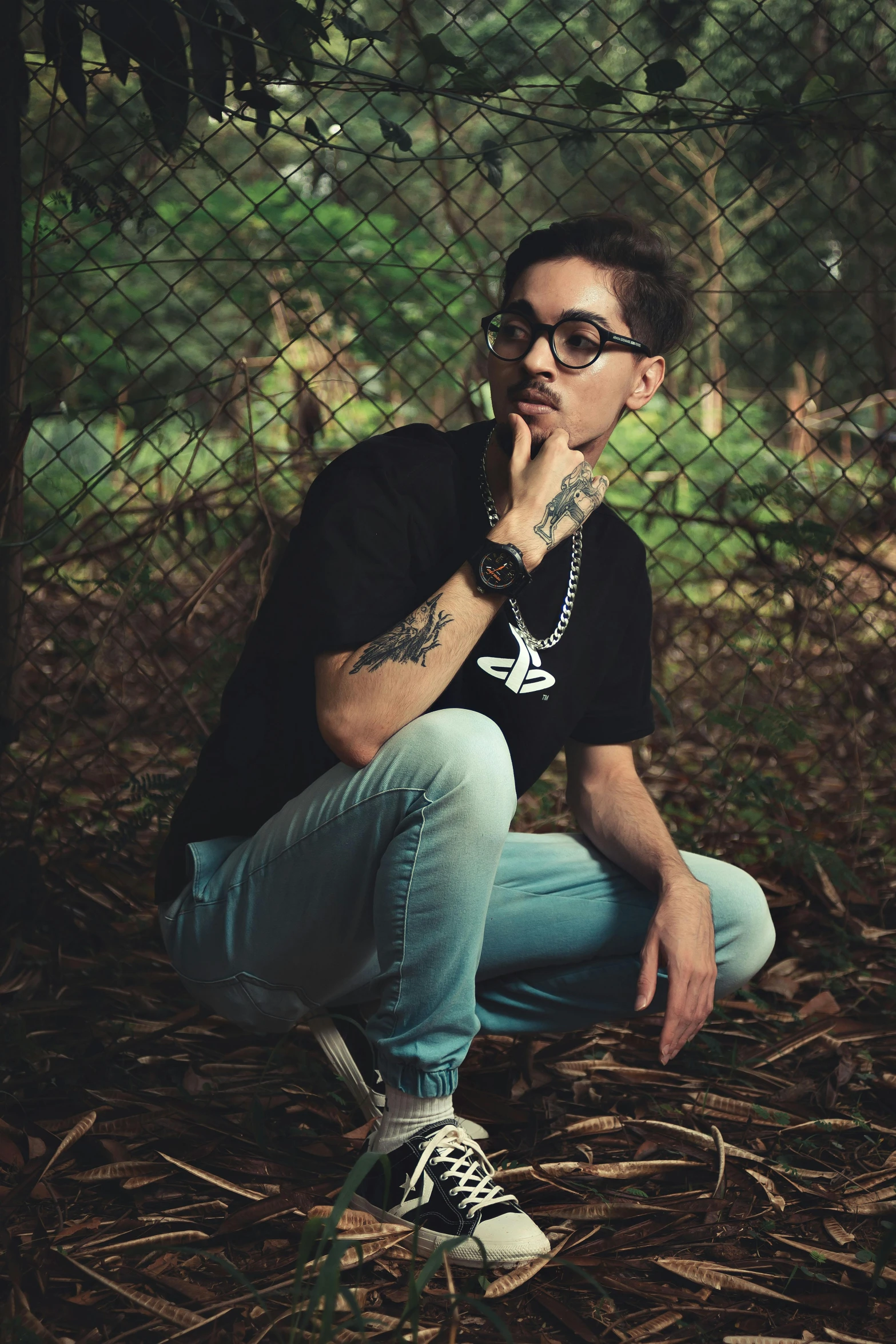 a man kneeling down with tattoos on his arm