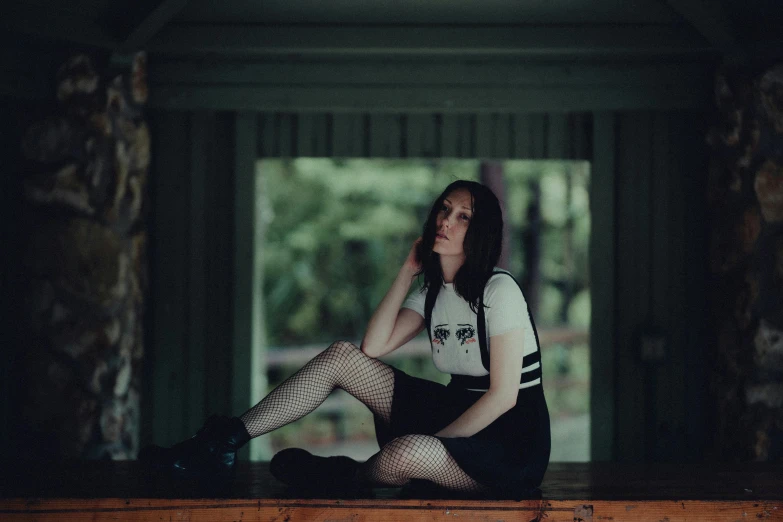 a woman in fish net stockings sitting on a ledge