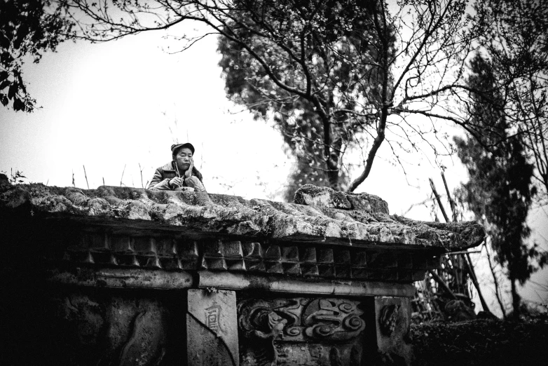 a boy is sitting on a cement structure