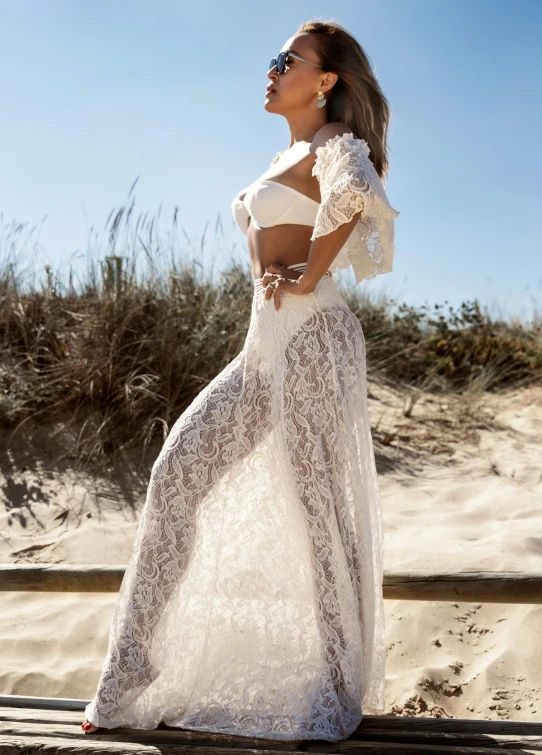 a woman is posing for a po on the beach