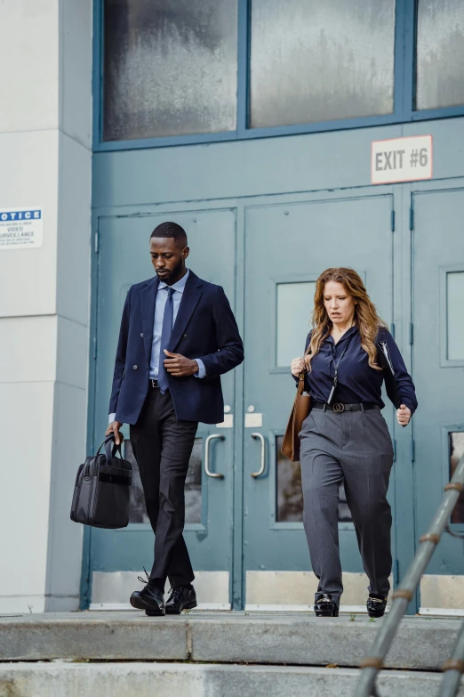 a man and woman are walking down steps together