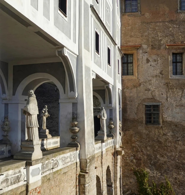 a building with statues and arch windows behind it