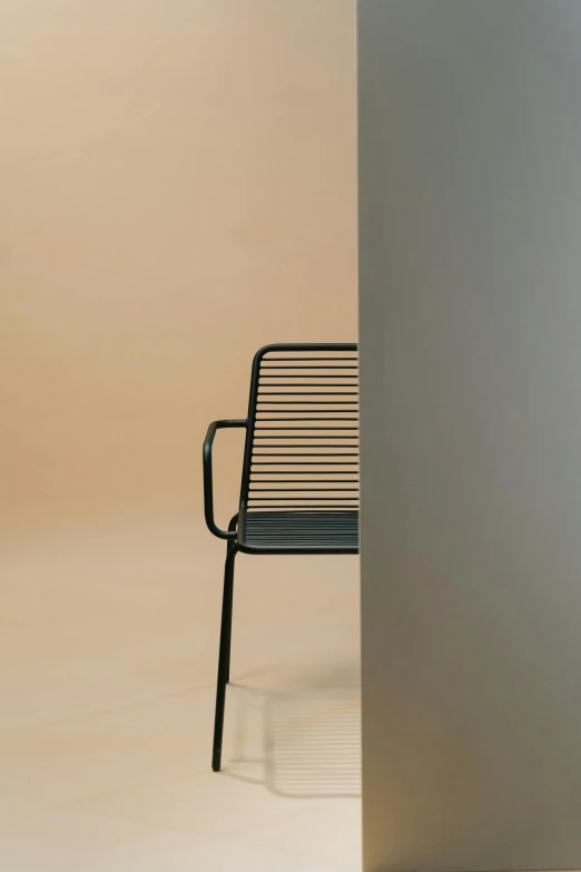 a black chair leaning against the side of a wall