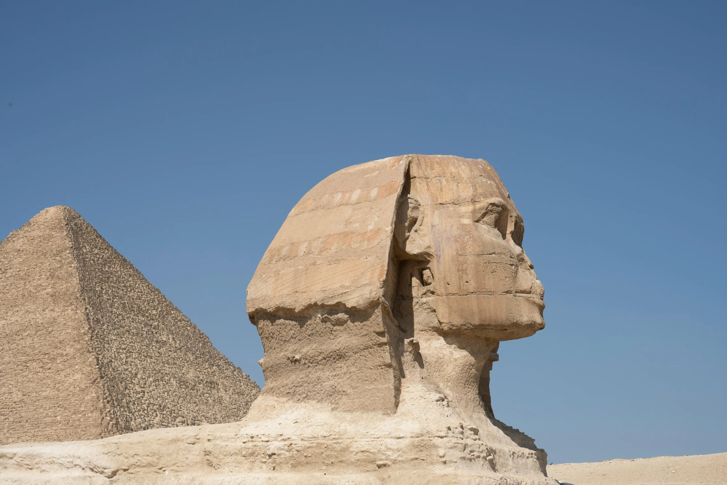 a po of two sphinxs in front of some very big pyramids