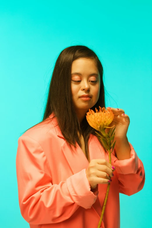 girl in pink shirt holding flowers with eyes closed