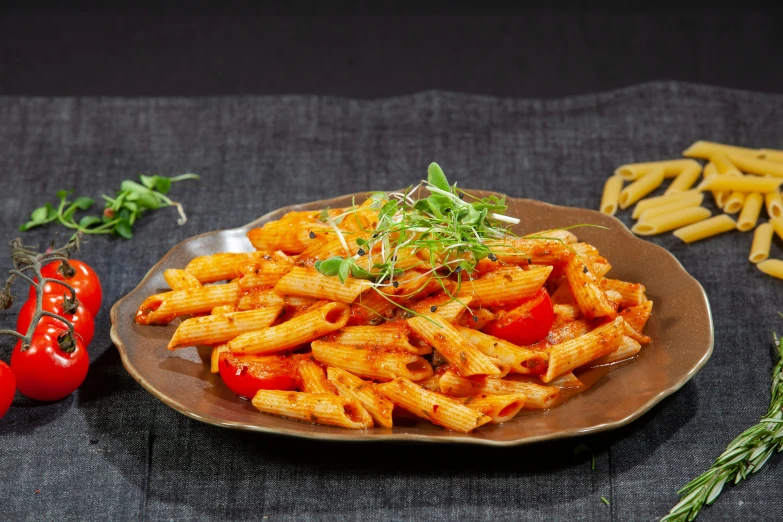 a brown plate filled with pasta and fresh herbs