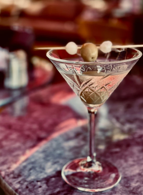 a martini sitting on top of a bar in a restaurant