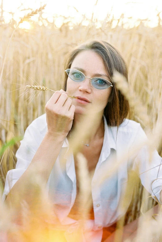 the  with the glasses is standing in a wheat field