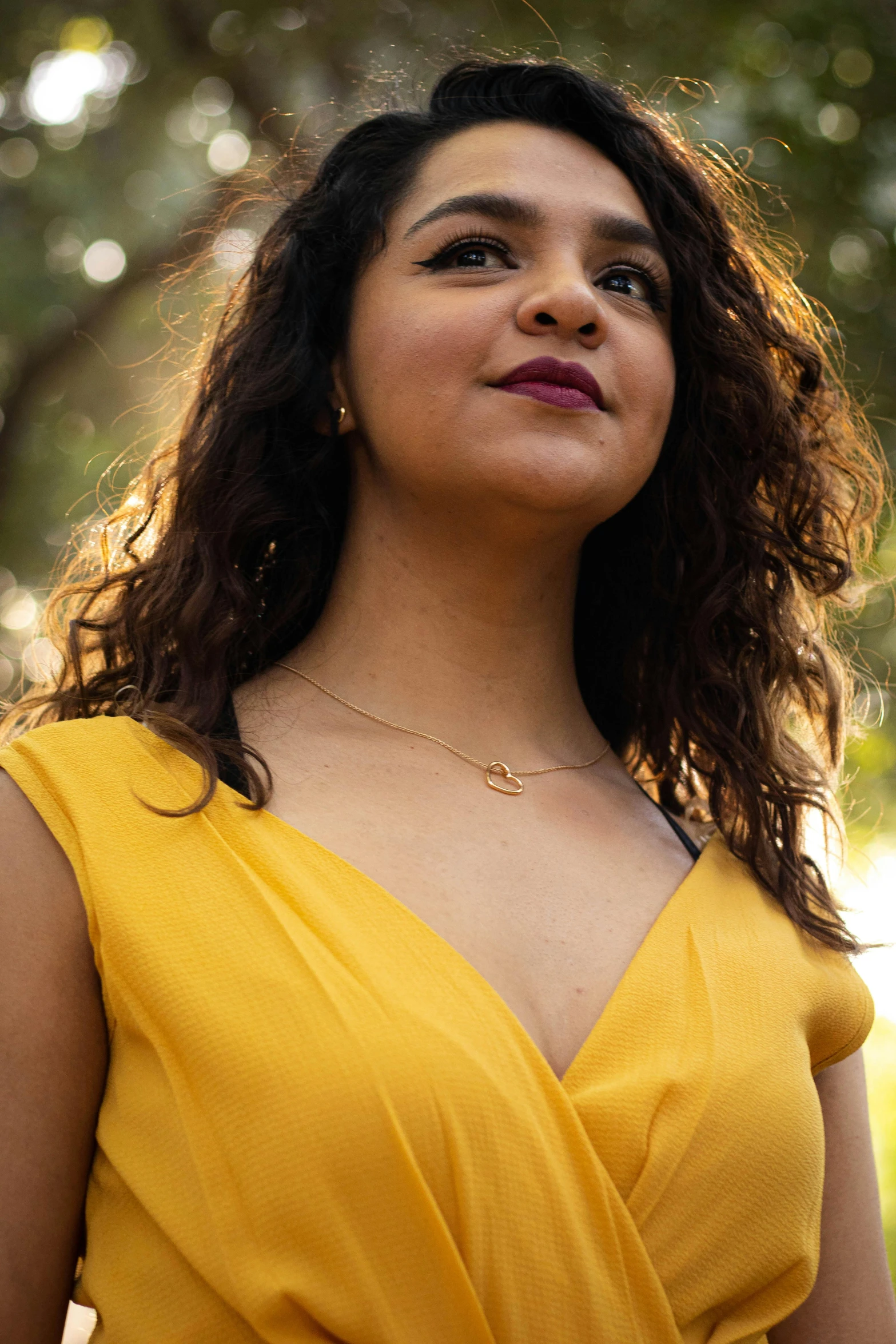 a woman in a yellow dress posing for a picture