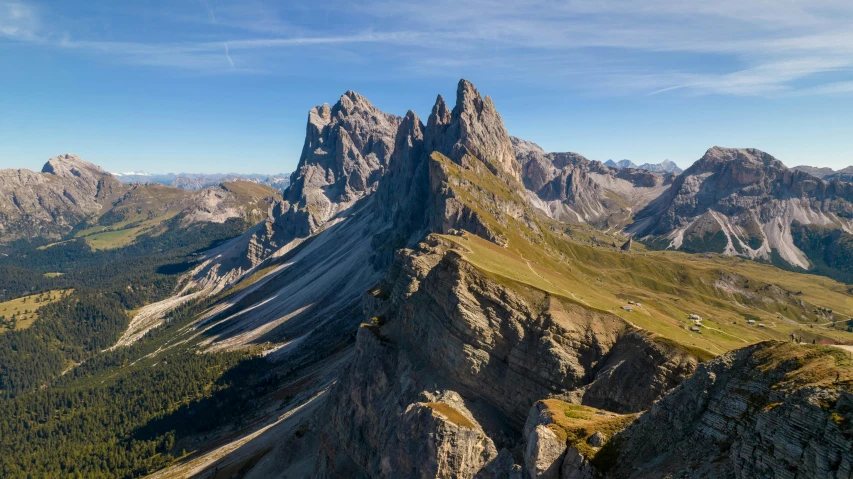 a view of a mountain with green grass