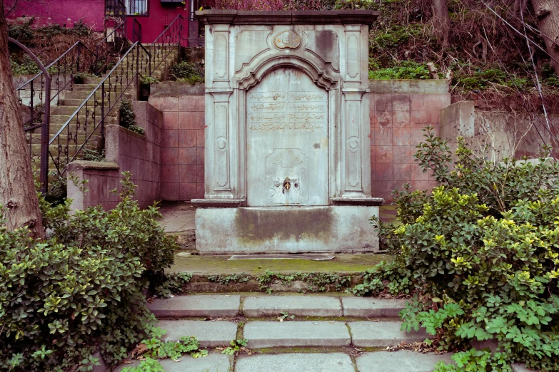 an old grave with steps and shrubs around it