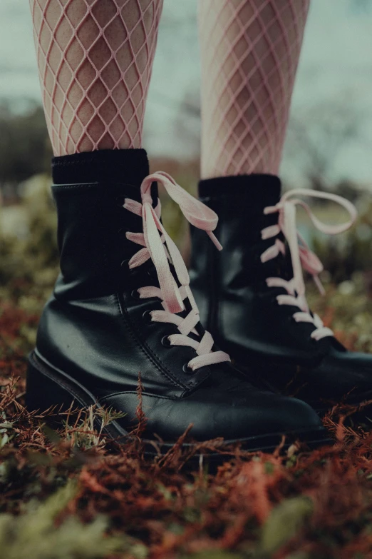 woman's black shoes on grass by the water