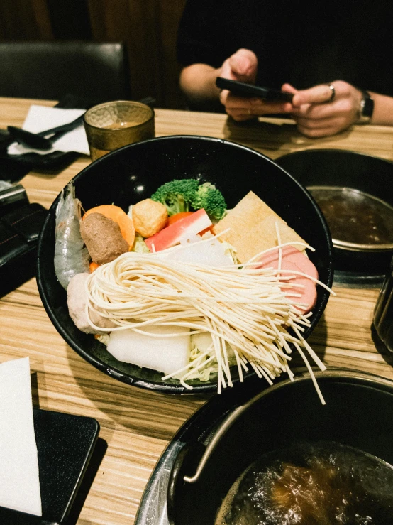 some food is on a black plate in front of two people