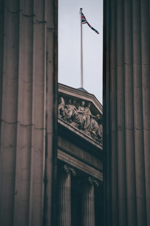 a view through pillars of a building with a flag on top