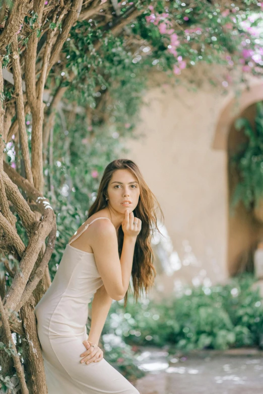 a woman poses in front of an archway