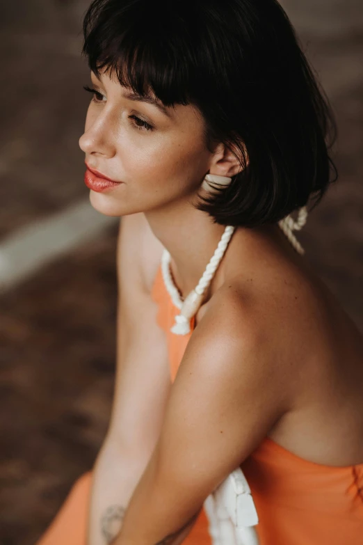 woman wearing orange top posing for pograph
