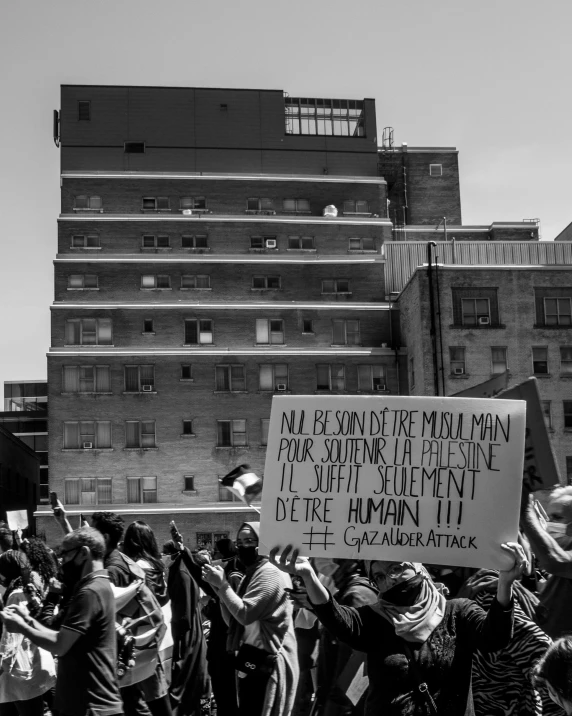 a man standing in front of a building holding a sign