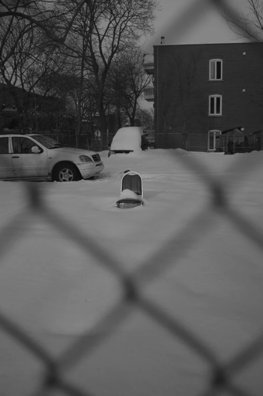 a black and white po of a parking lot is seen through a fence